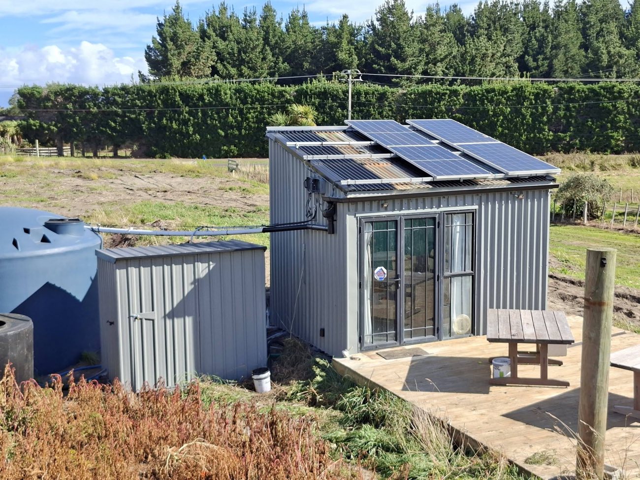 Repainted cabin with solar panels on a rural Manawatu property